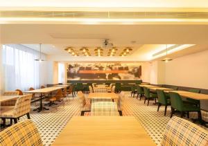 a restaurant with wooden tables and green chairs at City Comfort Premier Hotel Wuhan Wangjiawan Hanyang Bus Station Metro Station in Wuhan