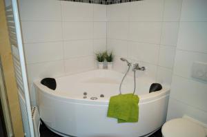 a bath tub in a bathroom with a green towel at Premium Apartments in Wendisch Rietz +26 photos