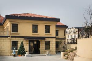 een huis met een kerstboom ervoor bij 青岛阿特拉酒店 in Qingdao