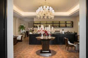 een eetkamer met een tafel en een kroonluchter bij 青岛阿特拉酒店 in Qingdao