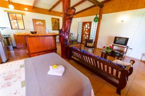 Sala de estar con cama y TV en Cabañas Moai, en Hanga Roa
