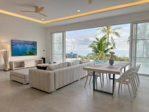 a living room with a couch and a table and a view of the ocean at Villa Nice in Lamai