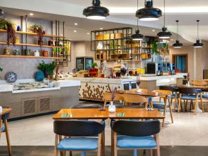 een restaurant met tafels en stoelen en een toonbank bij Novotel Istanbul Zeytinburnu in Istanbul