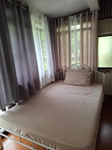 een bed in een kamer met twee ramen bij Hill View Home Stay Bohol in Panglao +15 foto's