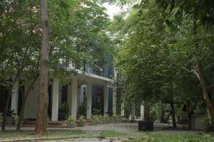 een wit huis met bomen ervoor bij Ayana Resort Wilpattu in Anuradhapura