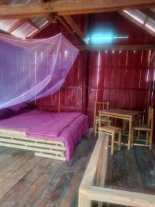a room with a bed and a table in it at The Two Tigers - Sok San Village in Phumĭ Kaôh Rŏng