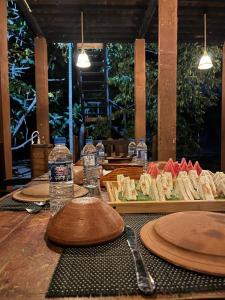 哈伯勒内Habarana Tree House - Ivory cottage的一张桌子,上面放有食物和水瓶