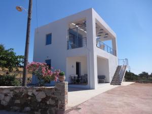 a white house with stairs and flowers in front of it at Eureka Kythira in Kythira