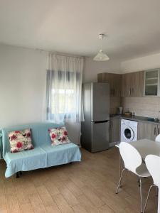 a living room with a blue couch and a kitchen at Eureka Kythira 