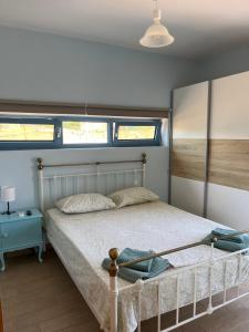 a bedroom with a bed and two windows at Eureka Kythira 