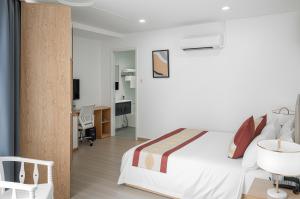 a bedroom with a bed and a desk and a chair at Vienna Hotel VN in Ho Chi Minh City