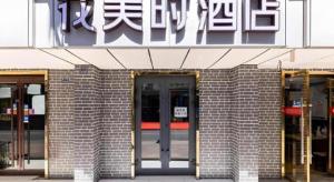 a brick building with a door and a sign on it at FERONIA Hotel Gansu Lanzhou Chengguan District Gannan Road in Lanzhou
