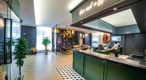 a man standing at a bar in a large room at City Comfort Premier Hotel Liuzhou Wuxing Pedestrian Street Jinggu Building in Liuzhou