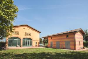 a large building with a garage and a grass field at B&B Giarola 25.2 in Cittanova