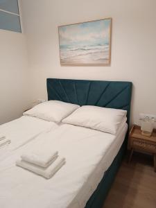 a bed with a green headboard and white pillows at Apartament 512 in Dziwnówek