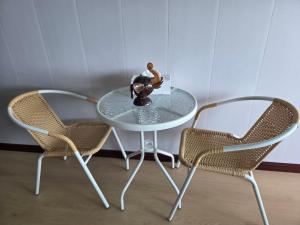 un tavolo di vetro con due sedie e un vaso sopra di Mong DOO SEA HOME  Altre 5 foto