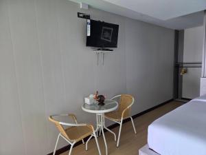 una camera con tavolo, sedie e TV a parete di Mong DOO SEA HOME 