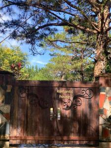 a wooden fence with a house sign on it at Romantic house on a pine hill Dalat in Xuan An