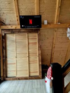 een kamer met houten wanden en een tv aan de muur bij Zori de zi in Lupeni +9 foto's