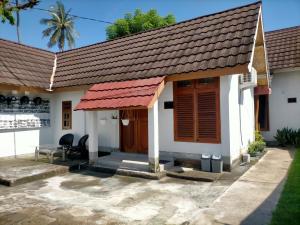 een klein wit huis met een rood dak bij Tania Homestay in Bumbang +15 foto's