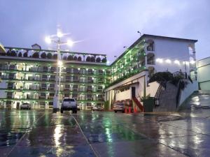 a large building with cars parked in a parking lot at Hotel Marques de Cima in Nogales