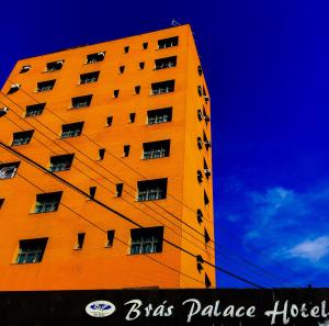 un edificio alto de color naranja con ventanas a un lado. en Bras Palace Hotel, en São Paulo