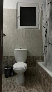 un bagno con un water e una tv a parete di Central Oasis a Alexandroupoli Altre 3 foto