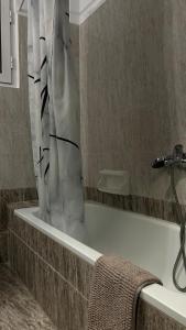 bagno con vasca e tenda doccia di Central Oasis a Alexandroupoli