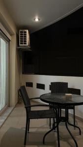 una sala da pranzo con tavolo, sedie e condizionatore d'aria di Central Oasis a Alexandroupoli