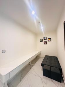 una stanza bianca con una panca e uno sgabello di Vinhomes Grand Park the Beverly a Gò Công Altre 6 foto