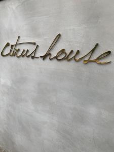 un cartello metallico con la scritta eitherhyde su un muro di citrus house a Wakayama