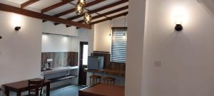 a room with a table and chairs and a television at The ED Corner - Hiriketiya in Dickwella