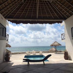 a resort with a swimming pool and the ocean at Casa Amor Pto Morelos in Puerto Morelos