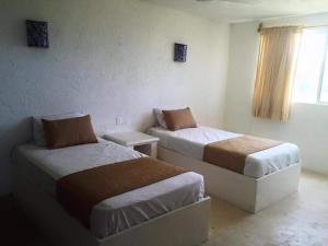 um quarto com 2 camas e uma janela em Casa Amor Pto Morelos em Puerto Morelos