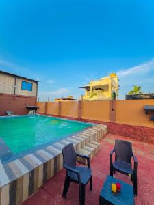 een zwembad bovenop een gebouw met twee stoelen bij empire villa in Malavli