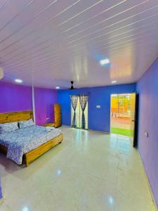 ein großes Zimmer mit einem Bett und lila Wänden in der Unterkunft empire villa in Malavli