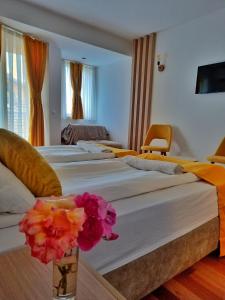 Zwei Betten in einem Zimmer mit Blumen in einer Vase in der Unterkunft Villa Nika Pestani in Peštani