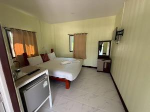 a small bedroom with a bed and a television at ต้นตาล&ตาลฟ้า รีสอร์ท in Ban Nong Khang
