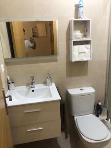een badkamer met een toilet, een wastafel en een spiegel bij La perle de tanger in Tanger