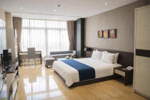a hotel room with a bed and a living room at Golden Queen Aparthotel in Ho Chi Minh City