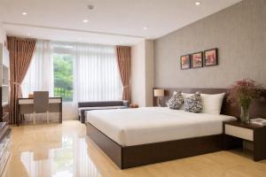 a bedroom with a large bed and a desk at Golden Queen Aparthotel in Ho Chi Minh City