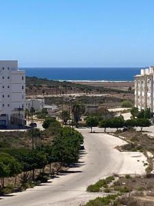 een lege weg voor een gebouw en de oceaan bij La perle de tanger in Tanger