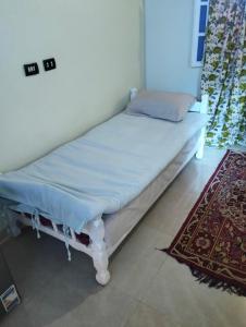 un piccolo letto in una stanza con un tappeto di Roma House a Aswan