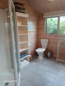 een badkamer met een toilet in een houten cabine bij A Waihi Beach Getaway in Waihi Beach
