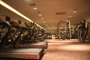 a gym with rows of treadmills and machines at China National Convention Center Grand Hotel in Beijing