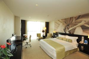Un dormitorio con una cama grande con un cuadro en la pared. en China National Convention Center Grand Hotel, en Beijing