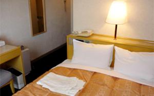 une chambre d'hôtel dotée d'un lit avec une lampe. dans l'établissement Hotel Crown Hills Yuki, à Yuki