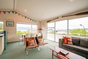 een woonkamer met een bank en een tafel bij Sea View Batch in Takaka