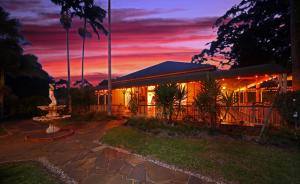 a building with a sunset in the background at Eden House Retreat in Yungaburra