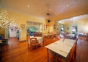 un restaurante con mesas y sillas en una habitación en Eden House Retreat, en Yungaburra